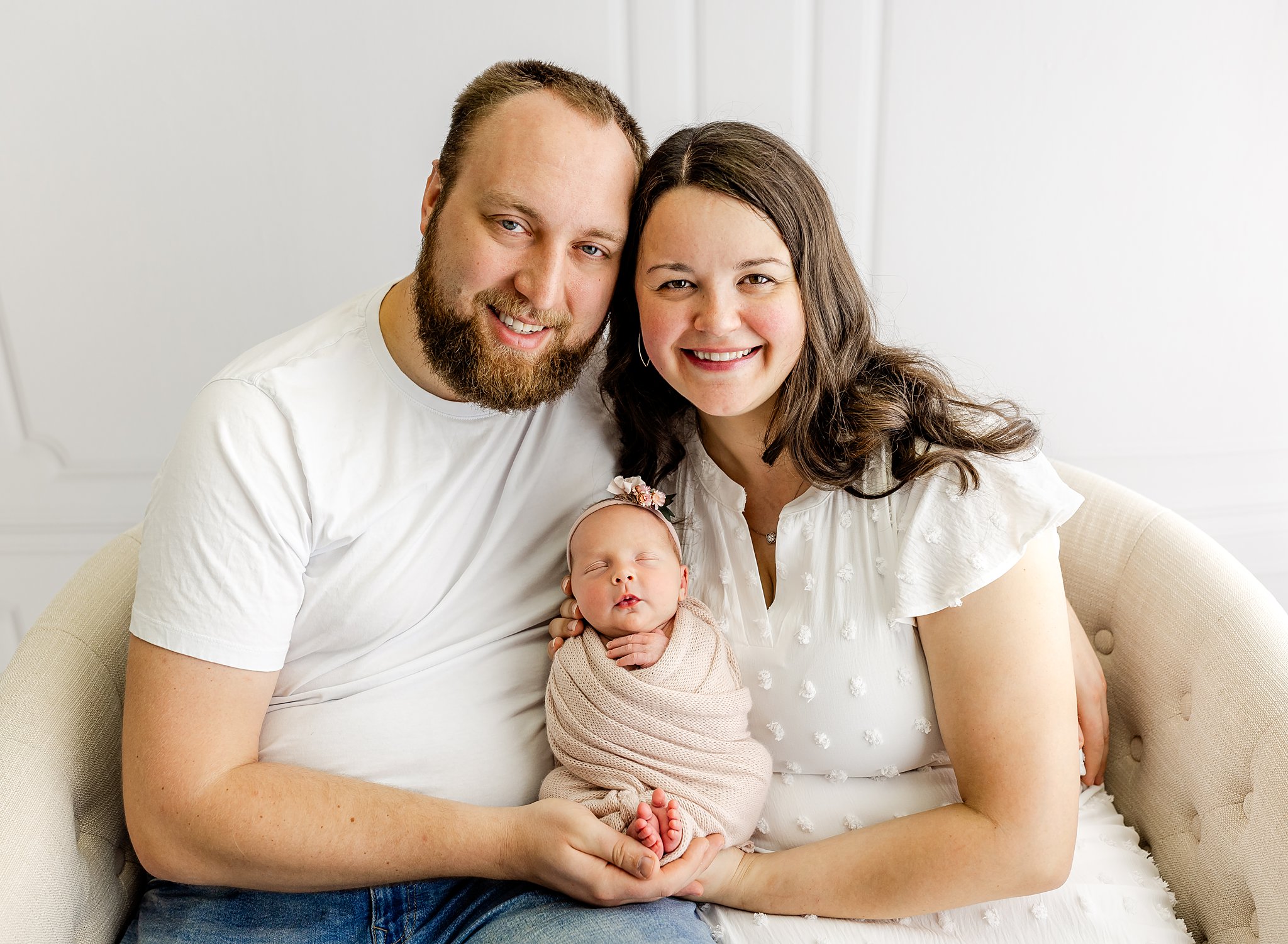 mom and dad holding their newborn girl
